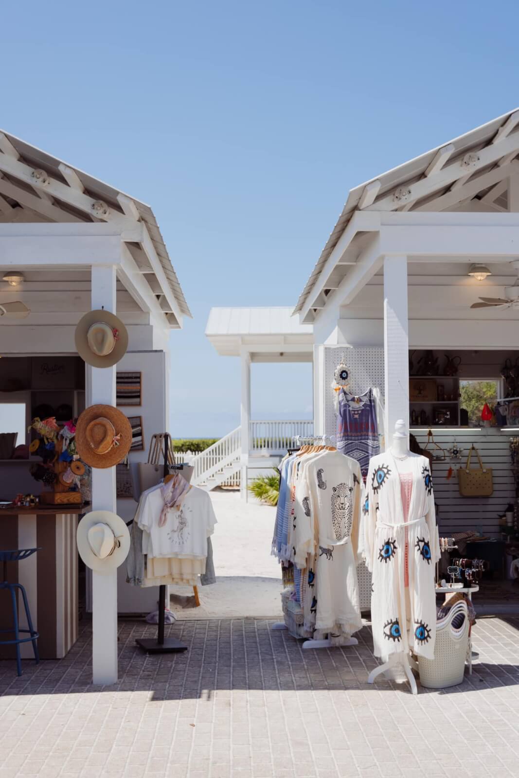 A shop with hats and clothes on the beach.