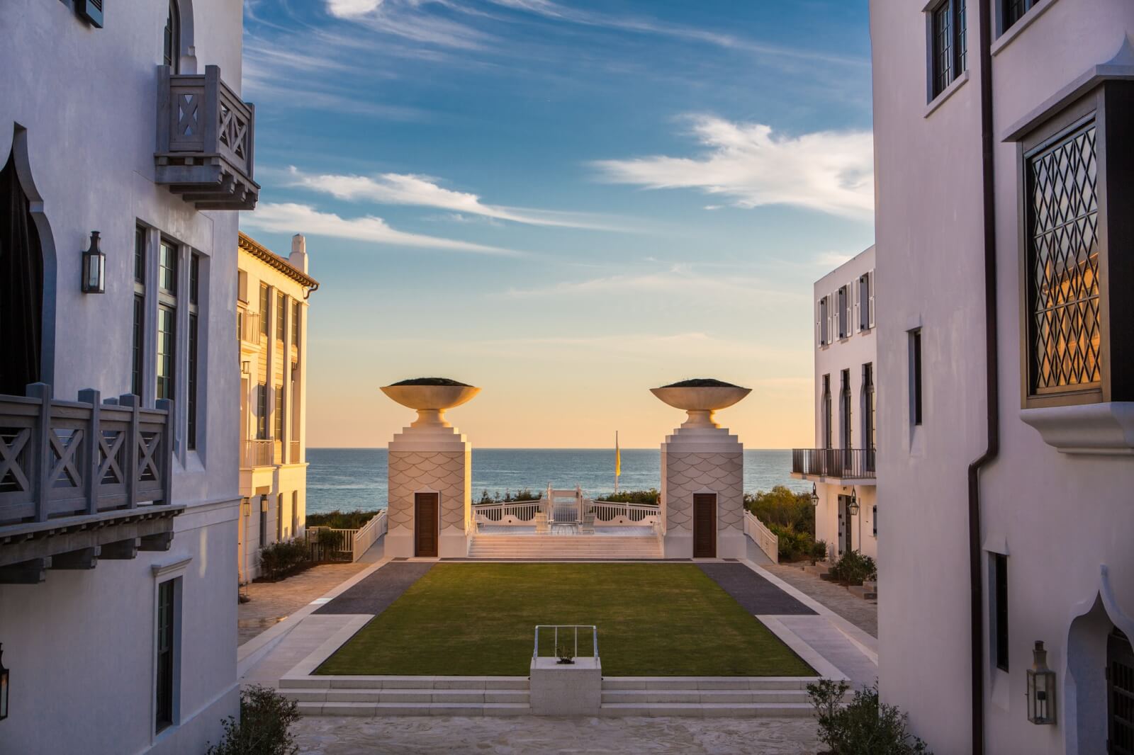 A courtyard with a fountain and a view of the ocean.