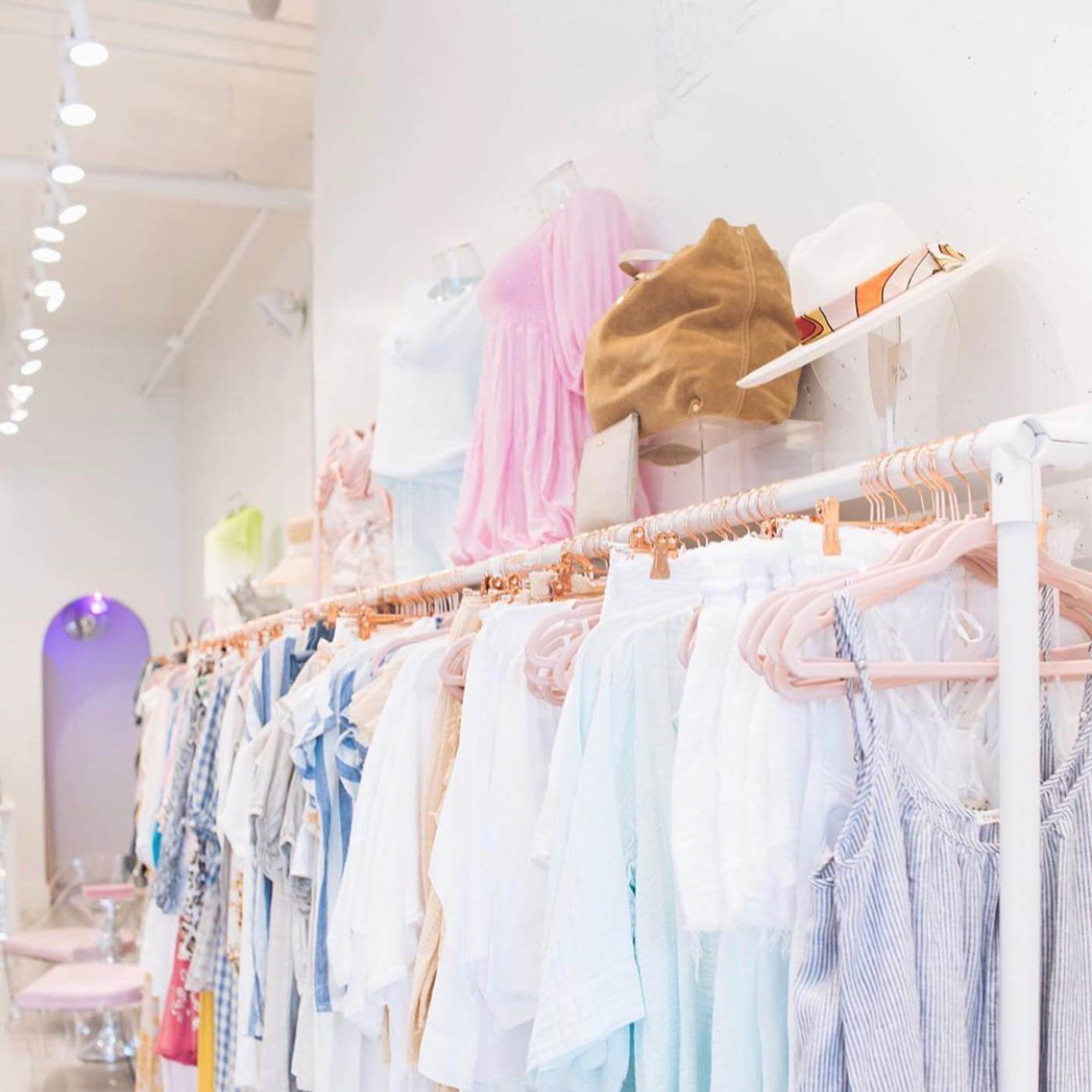 A clothing store with racks of clothes and hats.