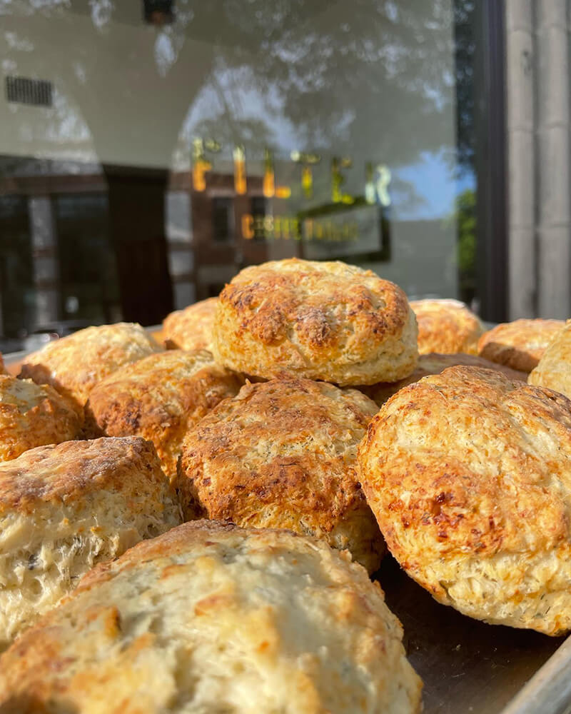 A close-up of freshly baked scones piled on a plate outside a Birmingham café, perfect for afternoon tea.