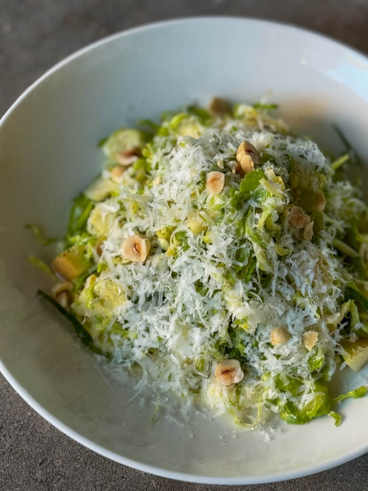 Discover one of Birmingham's best salads: a bowl of shredded Brussels sprouts salad topped with grated cheese and hazelnuts.