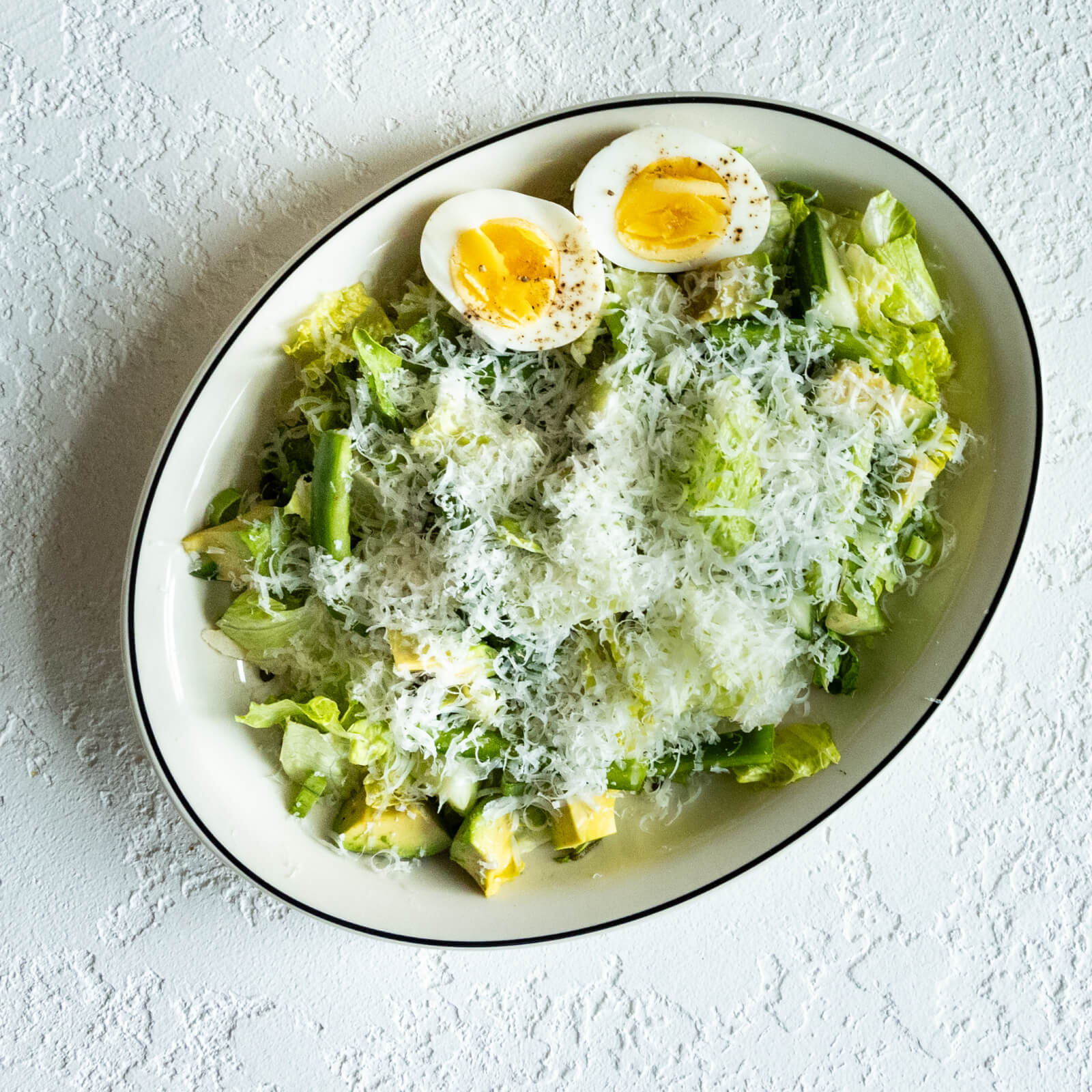 Discover one of Birmingham's best salads: a Caesar delight on a white plate, crowned with grated cheese and two halves of a soft-boiled egg.