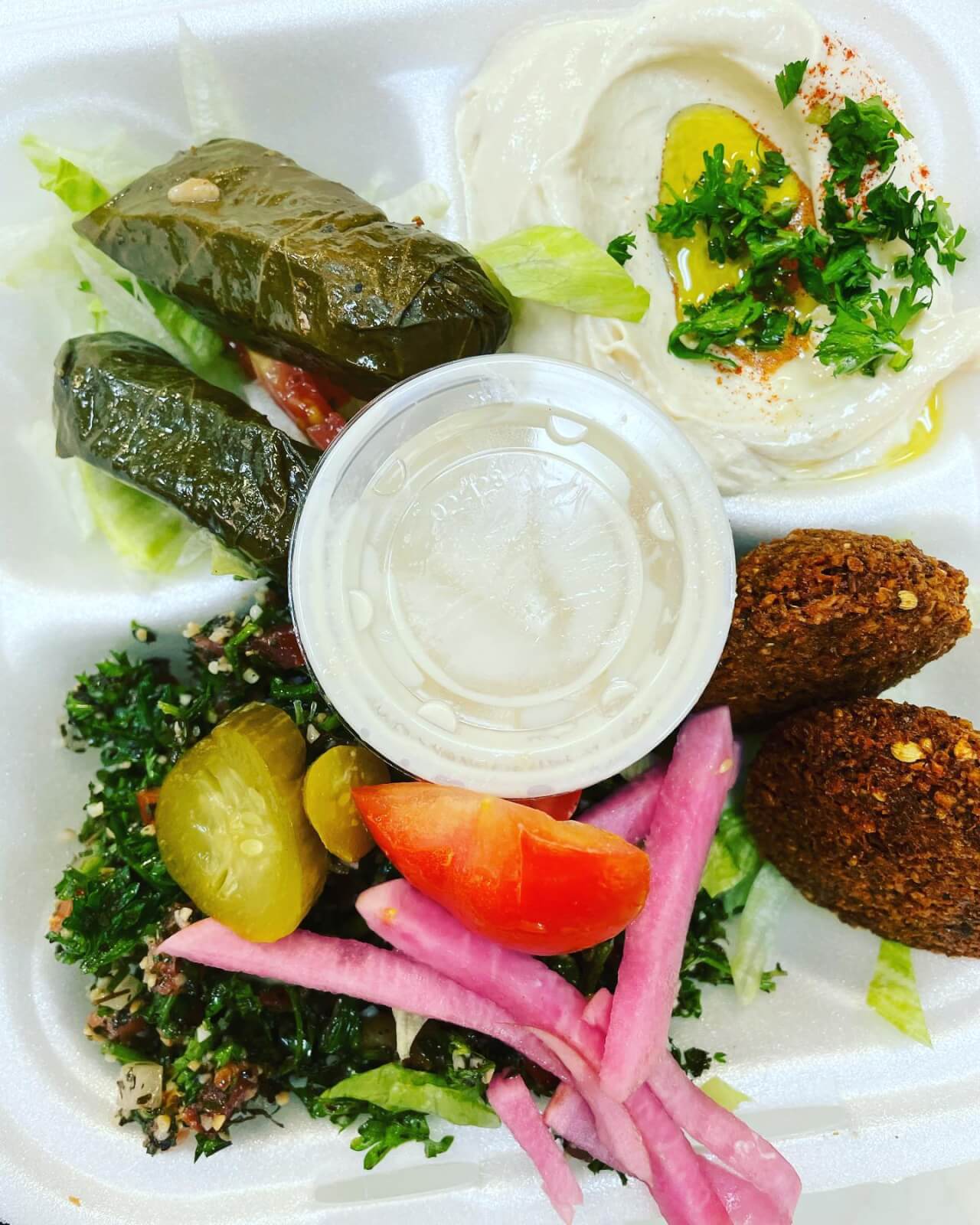 styrofoam plate filled with a Mediterranean veggie mix