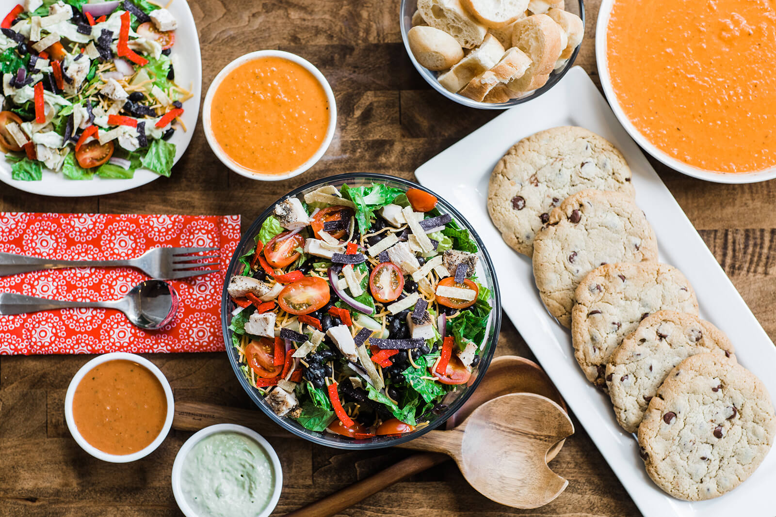 salads, cookies, and bread laid out on dishes on a table