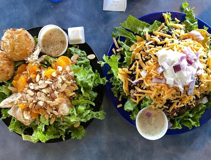 two salads on blue tabletop