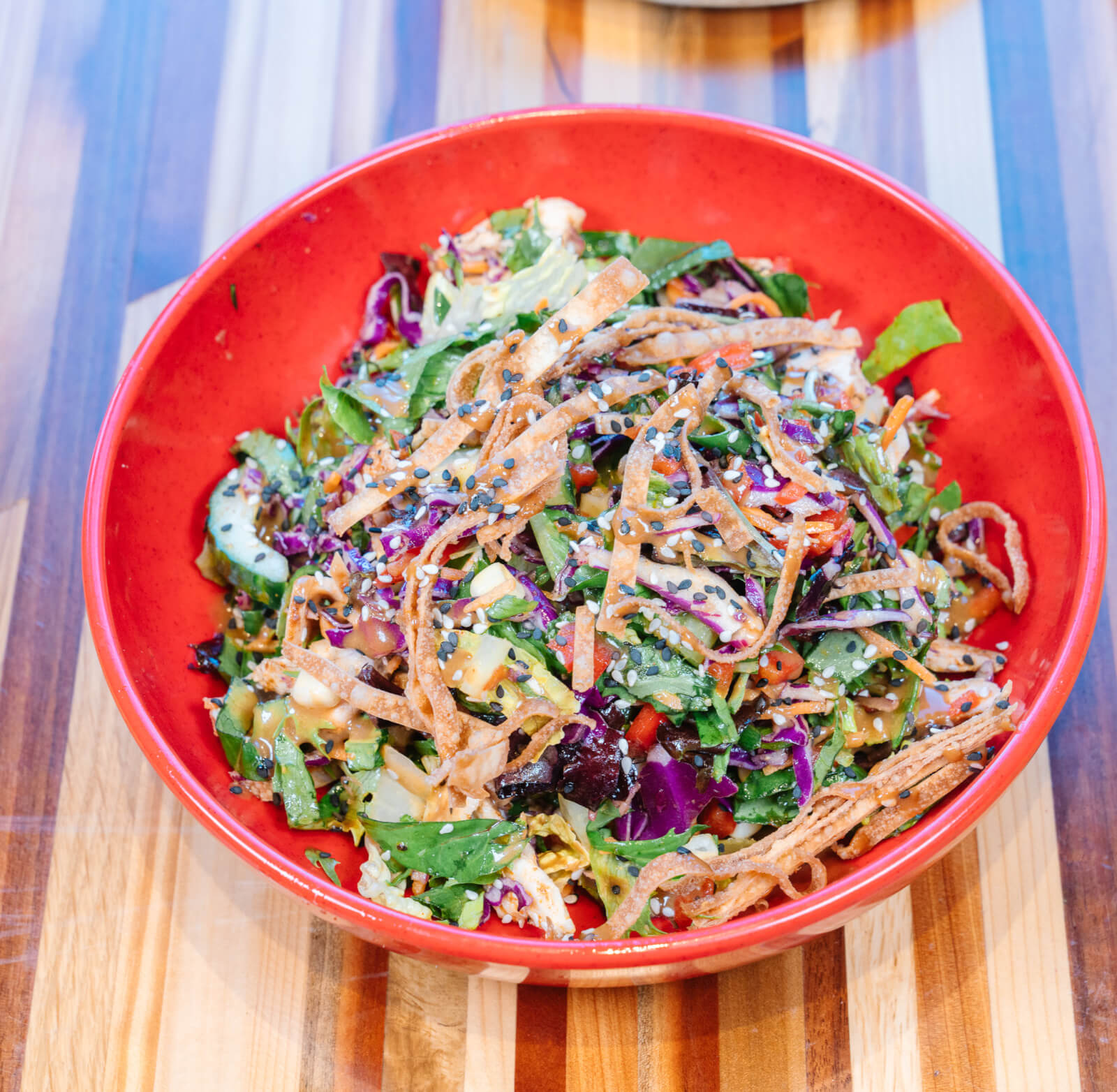 Thai peanut chicken salad in red bowl