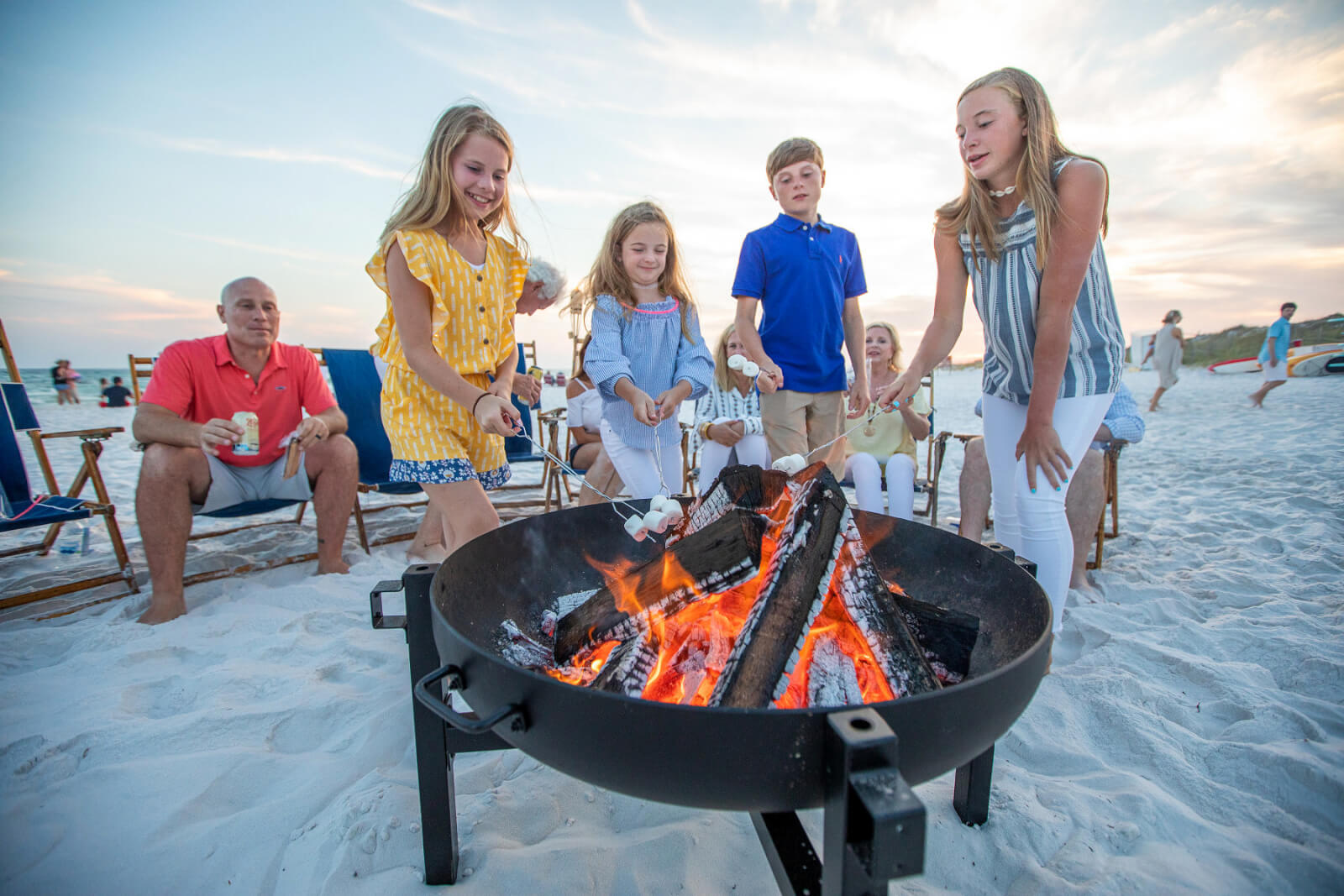 Family roasting s'mores at beach bonfire