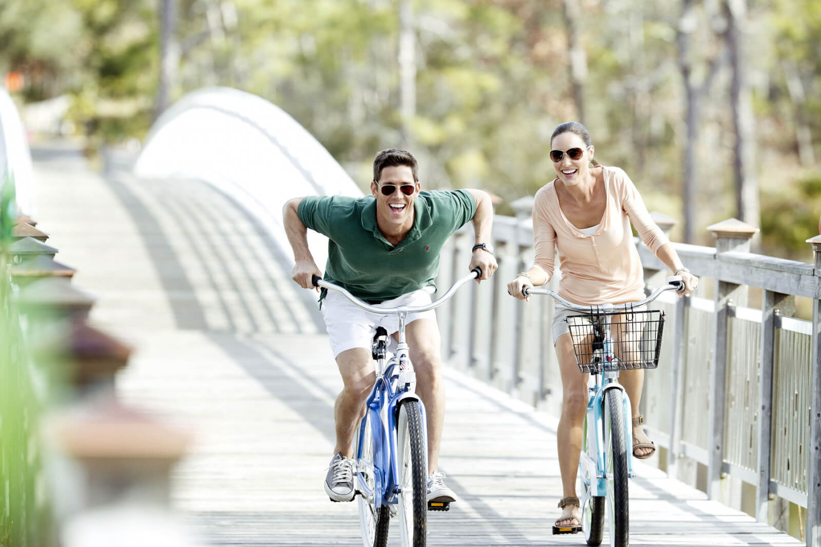 Young couple riding bikes along a wooden bridge