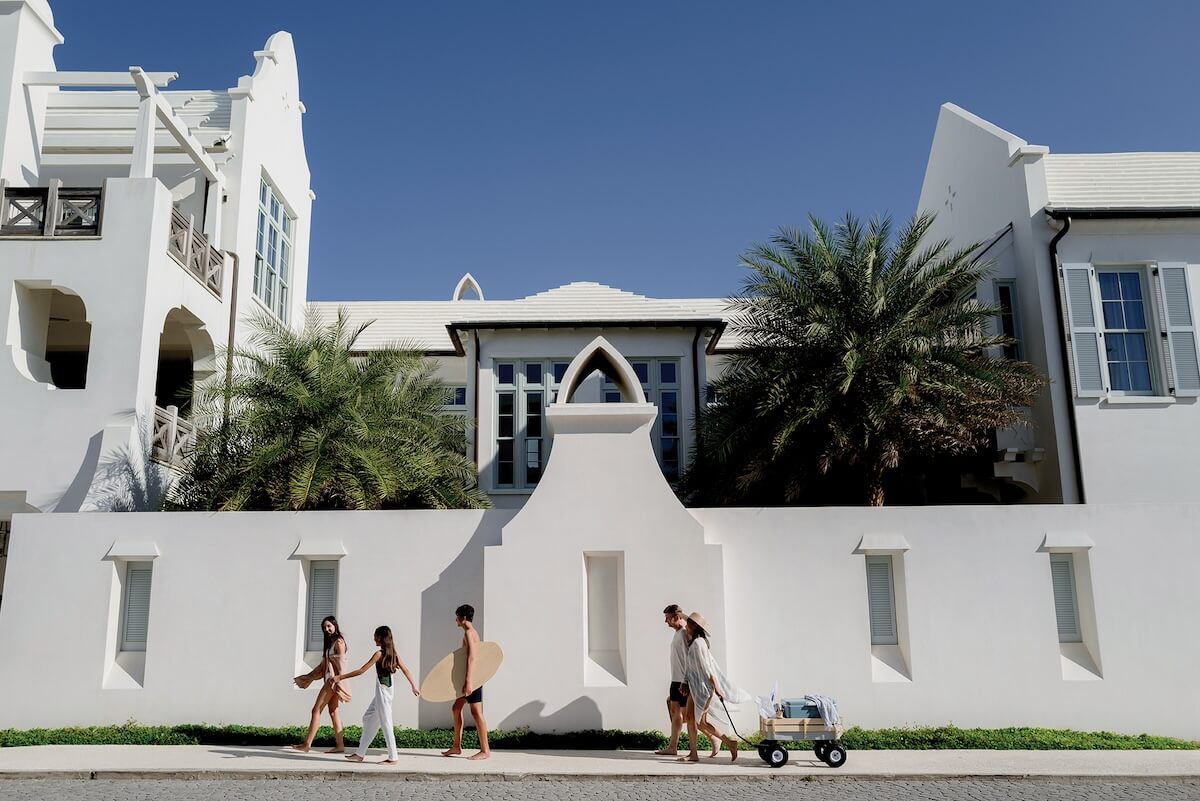 People walking by white homes in Alys Beach, FL.