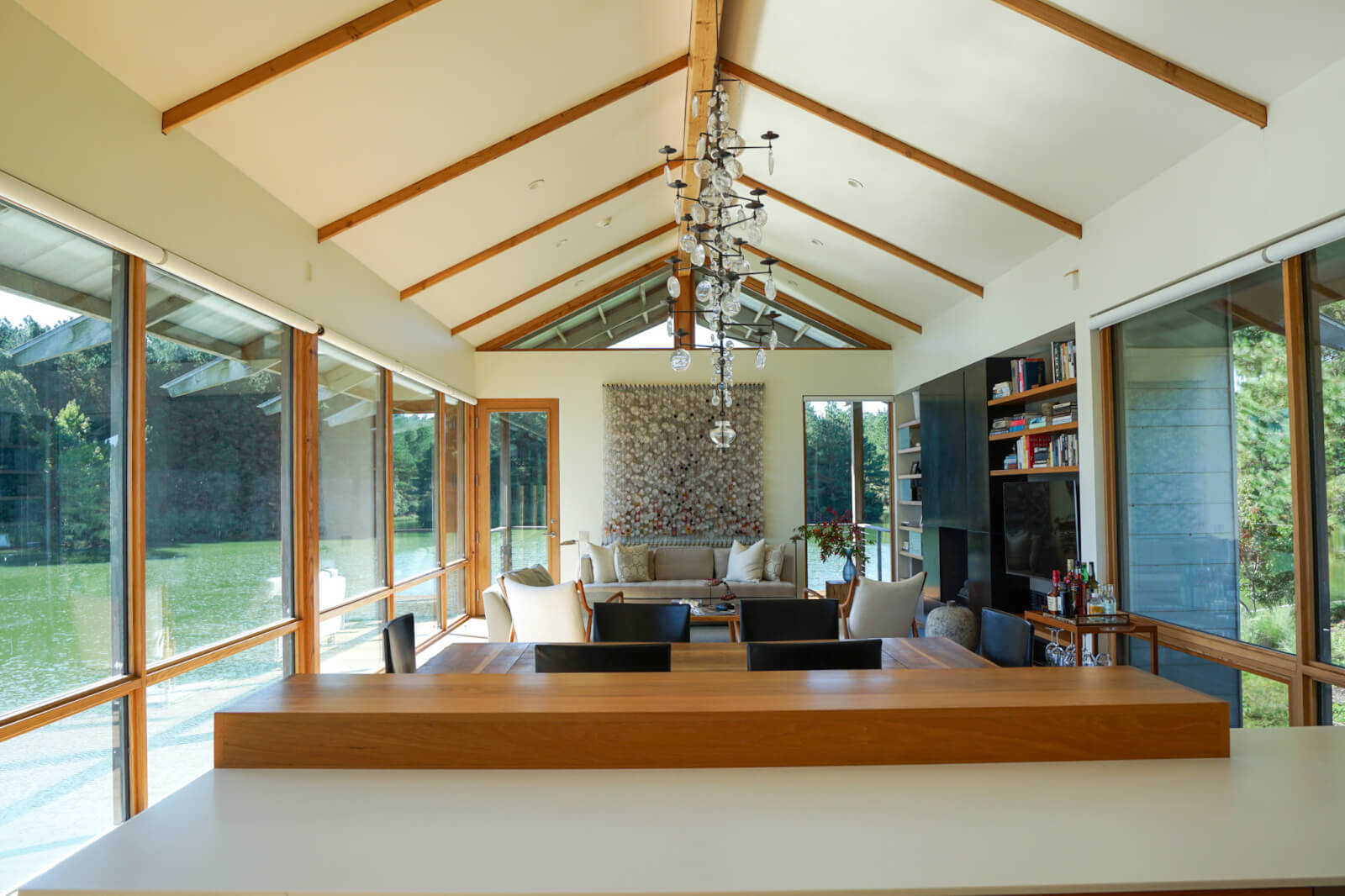 Living room with beamed ceiling and floor-to-ceiling windows.