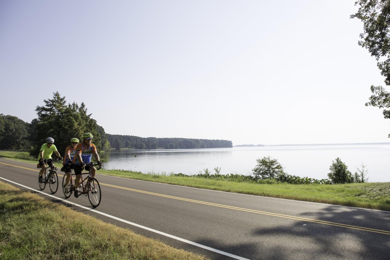 Three people biking along Natchez Trace Parkway in Ridgeland, MS, a Southern town to visit in the summer