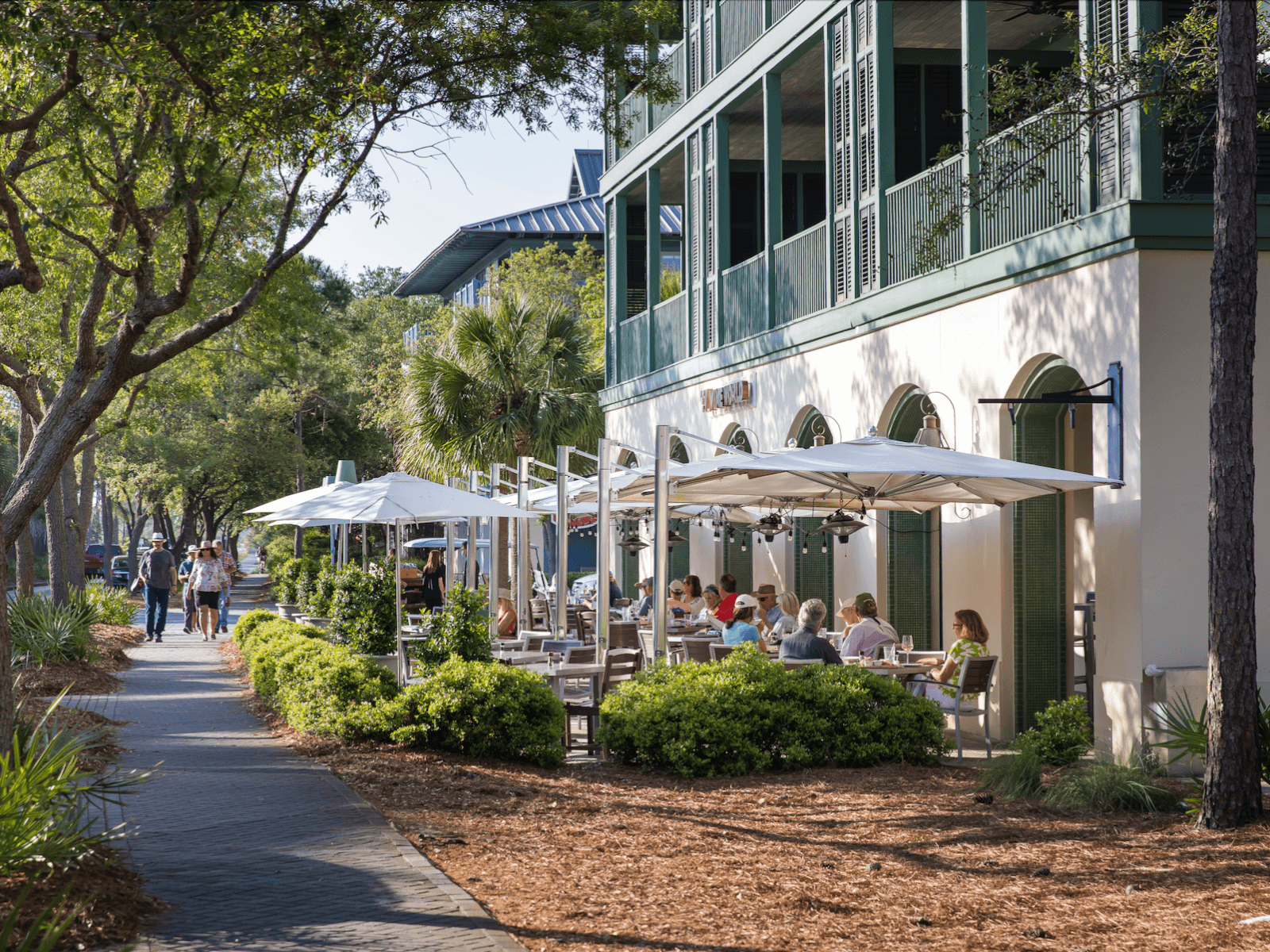 A sidewalk with tables and chairs.