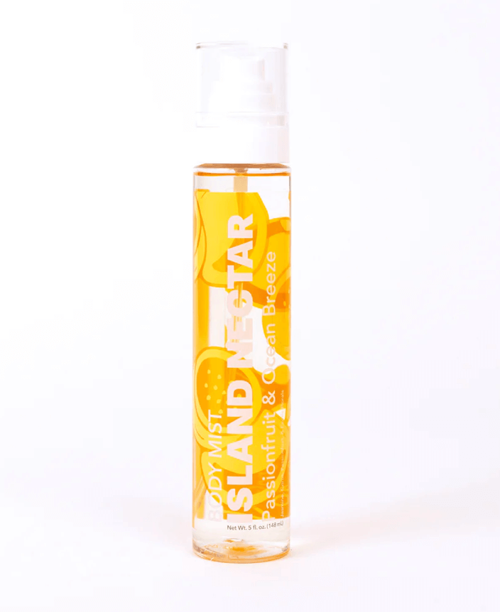 A clear bottle of body mist labeled "Island Nectar: Passionfruit & Ocean Breeze" with a floral design, perfect for starting the New Year refreshed and revitalized.