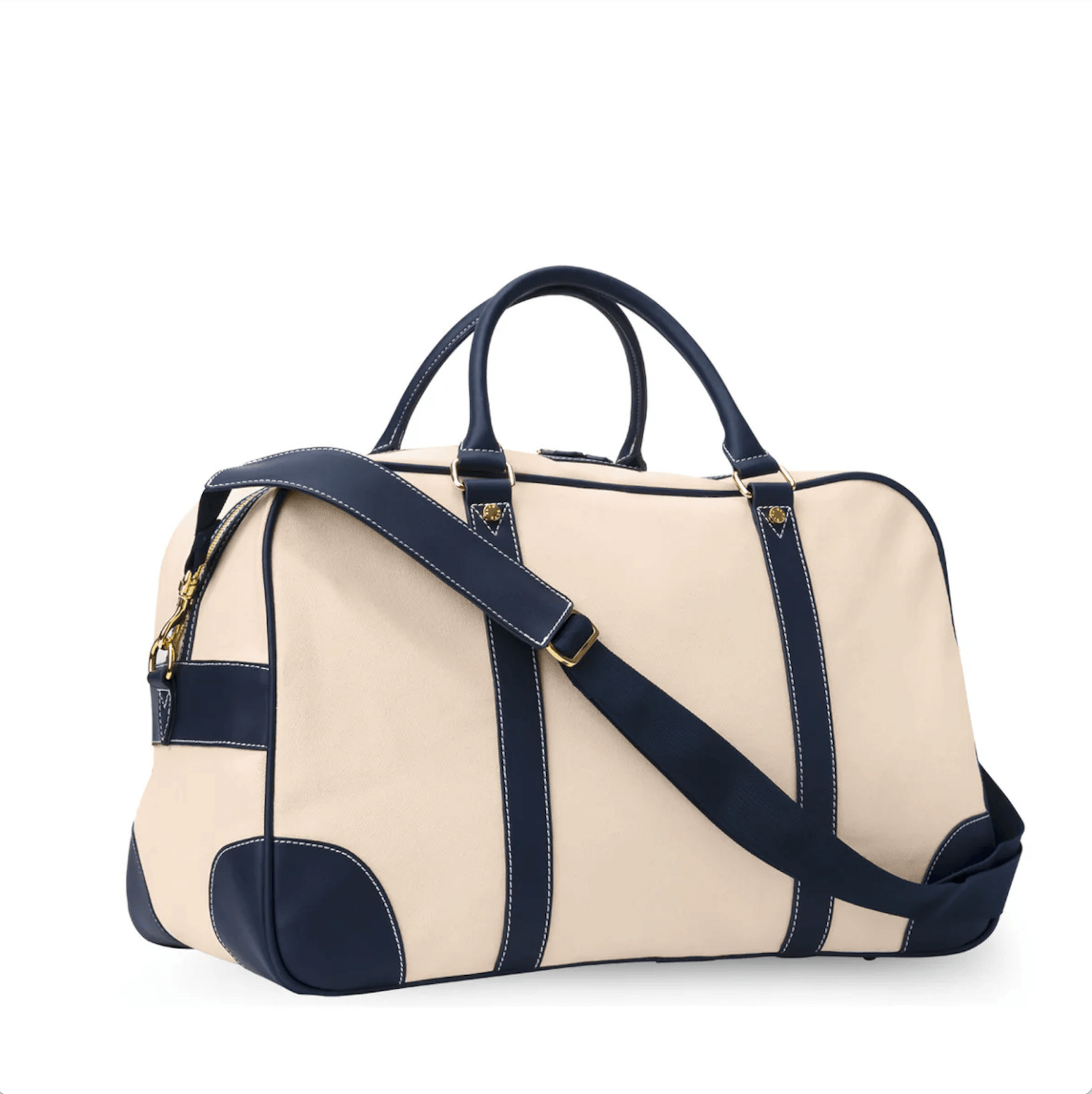 Beige and navy leather-trimmed duffle bag boasts dual handles and an adjustable shoulder strap for versatile carrying.