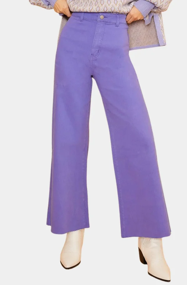 In a chic ensemble perfect for exploring Memphis in January 2025, the person dons high-waisted purple wide-leg pants paired with stylish white ankle boots. The look is completed with a partly visible top, epitomizing effortlessly cool FINDS for the fashion-forward.